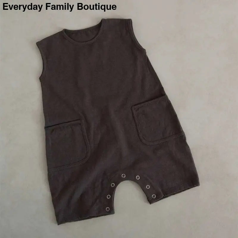 Brown sleeveless romper with patch pockets and snap closures at the bottom.