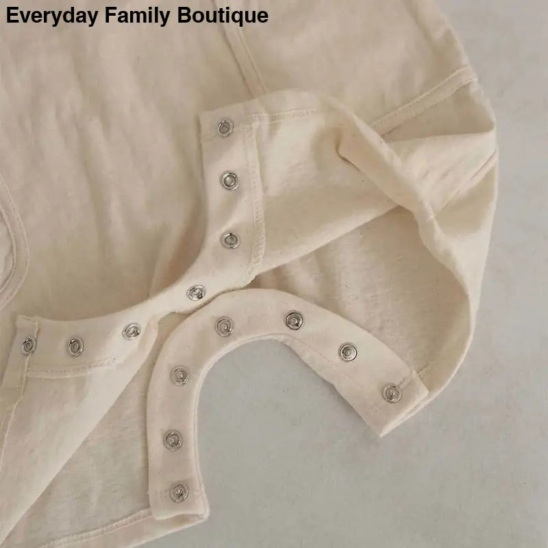 White fabric garment with metal snap buttons.