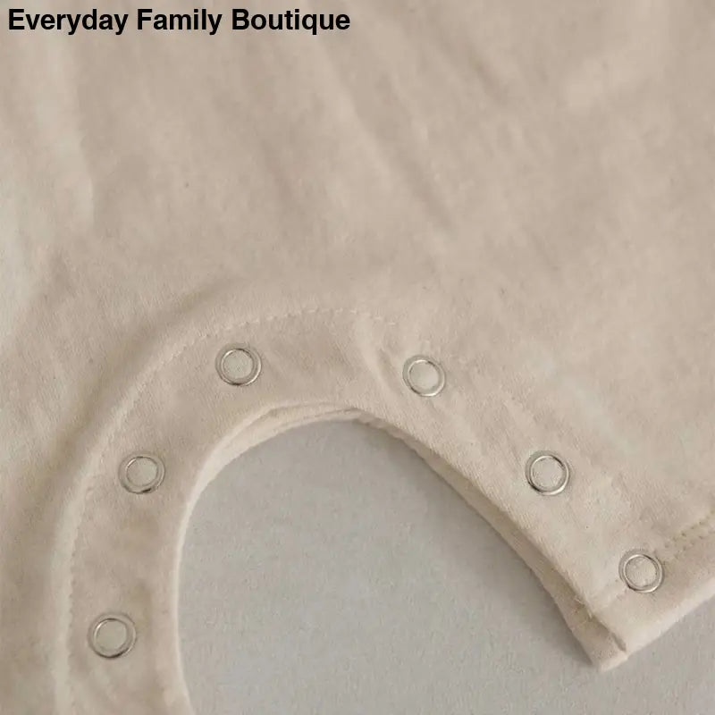 White fabric with metal snap buttons arranged in a curved line.