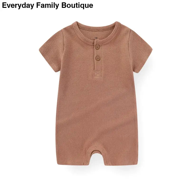 Brown ribbed cotton romper with short sleeves and button placket.