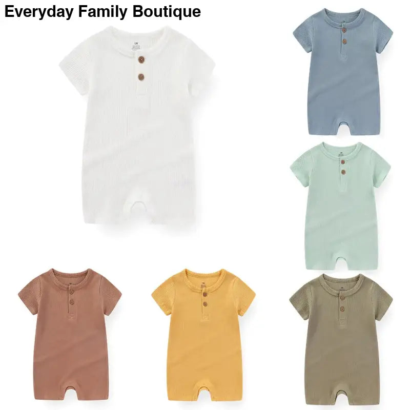 Collection of baby rompers in different muted colors with button plackets and short sleeves.