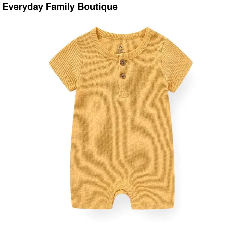 Yellow ribbed cotton romper with short sleeves and button placket.