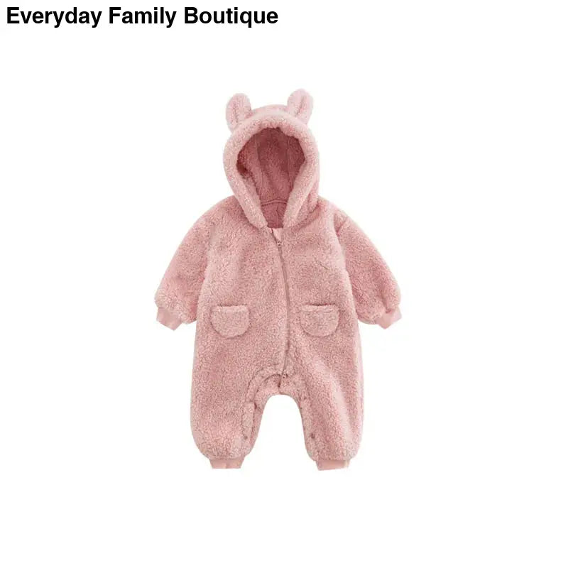 Pink fluffy baby romper with bear ears on the hood and front pockets.