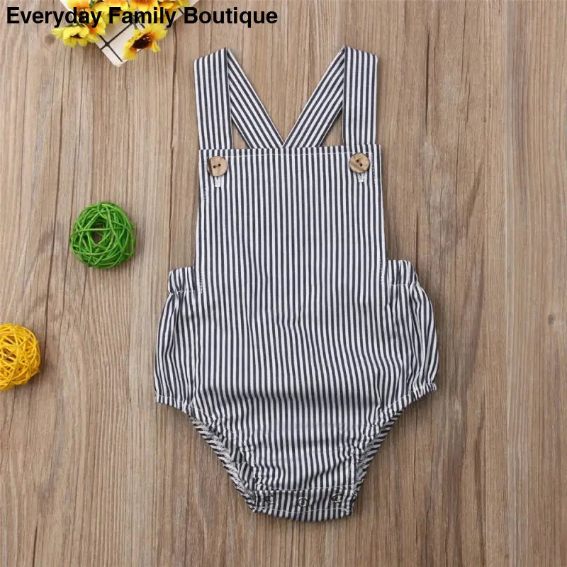 Striped gray and white baby romper with crossed shoulder straps.