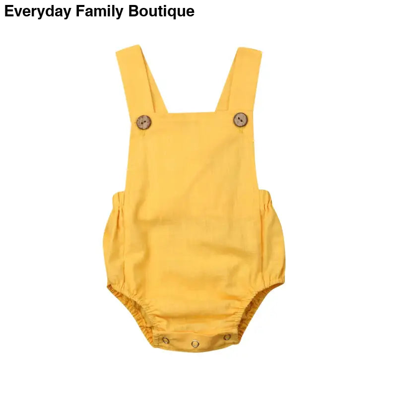 Yellow cotton baby romper with shoulder straps and button closures.